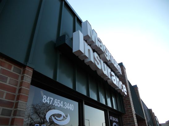 Magnum Insurance.  LED lighted channel letters on a raceway custom painted to match building facade.